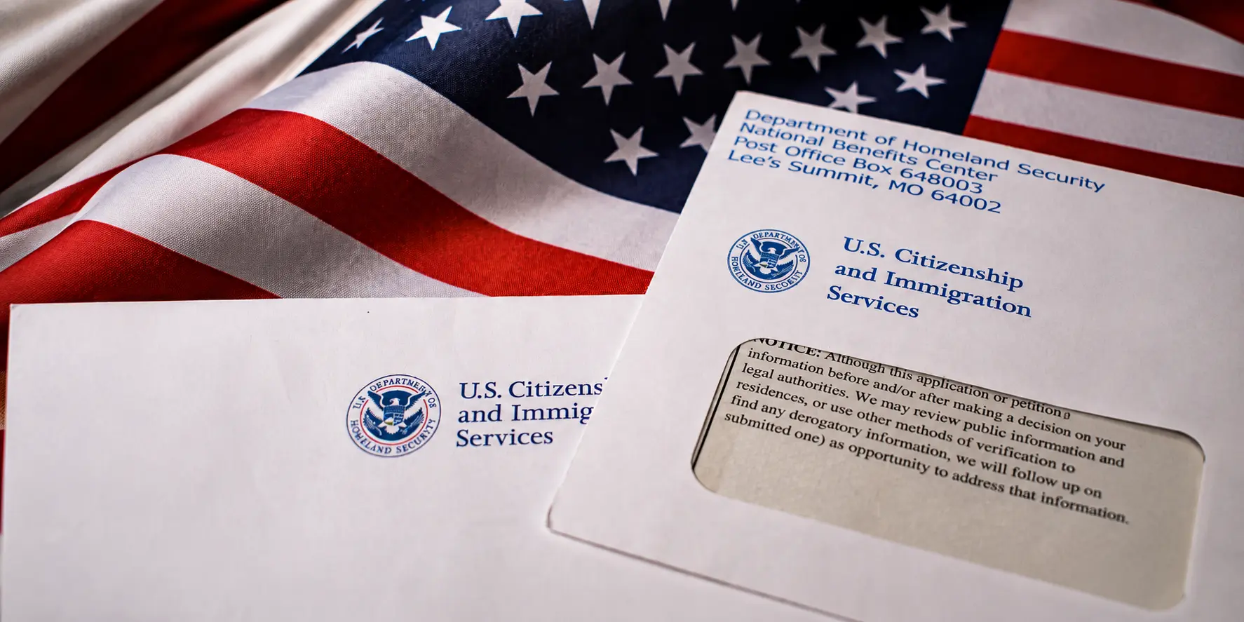 Documentos de USCIS junto a una bandera de Estados Unidos